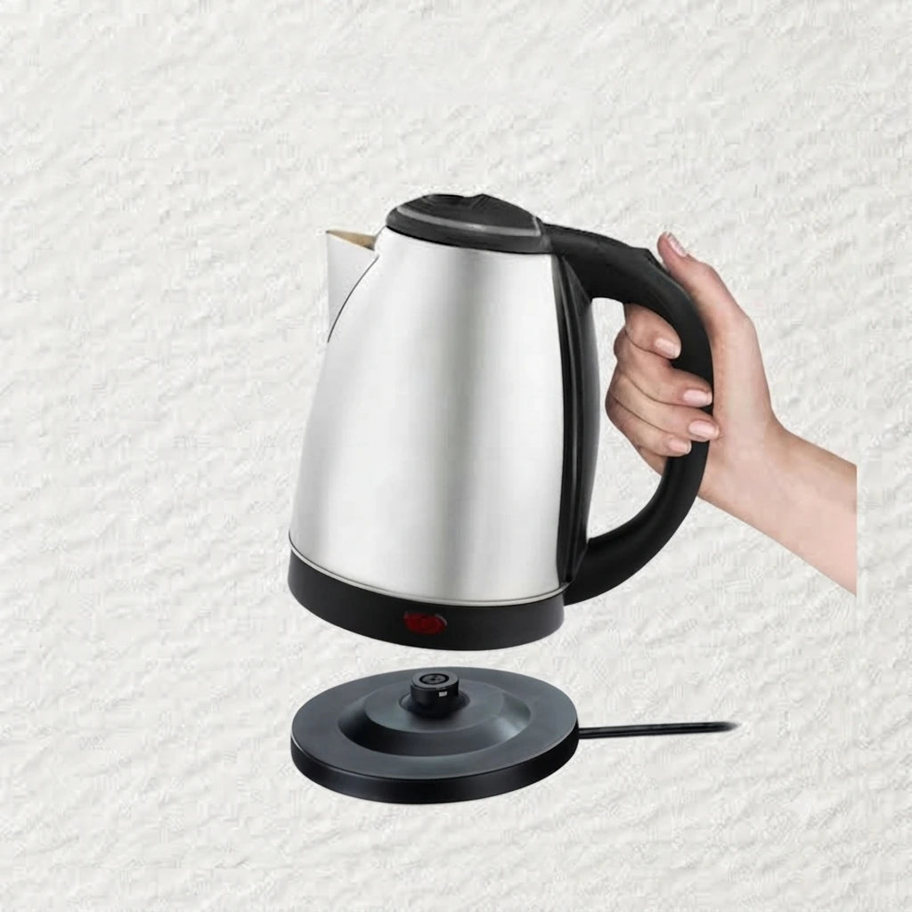 Stainless steel kettle with a cup of tea and cookies on a beige background
