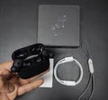 Black Airpods 2nd gen with a USB cable and strap
